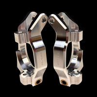 A pair of silver billet spindle carriers for RC cars, showing intricate machining and black hardware.