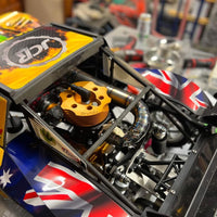Close-up of a model car with visible branding and flags on a blurred background
