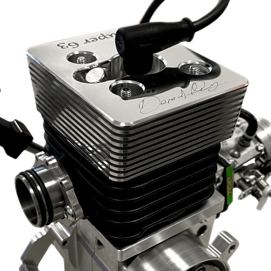 Close-up of a silver engine block with visible branding on a white background