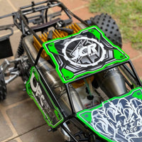 Close-up of a green and black RC car with visible branding on a tiled floor.
