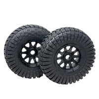 Two black off-road tires with tread patterns on a transparent background
