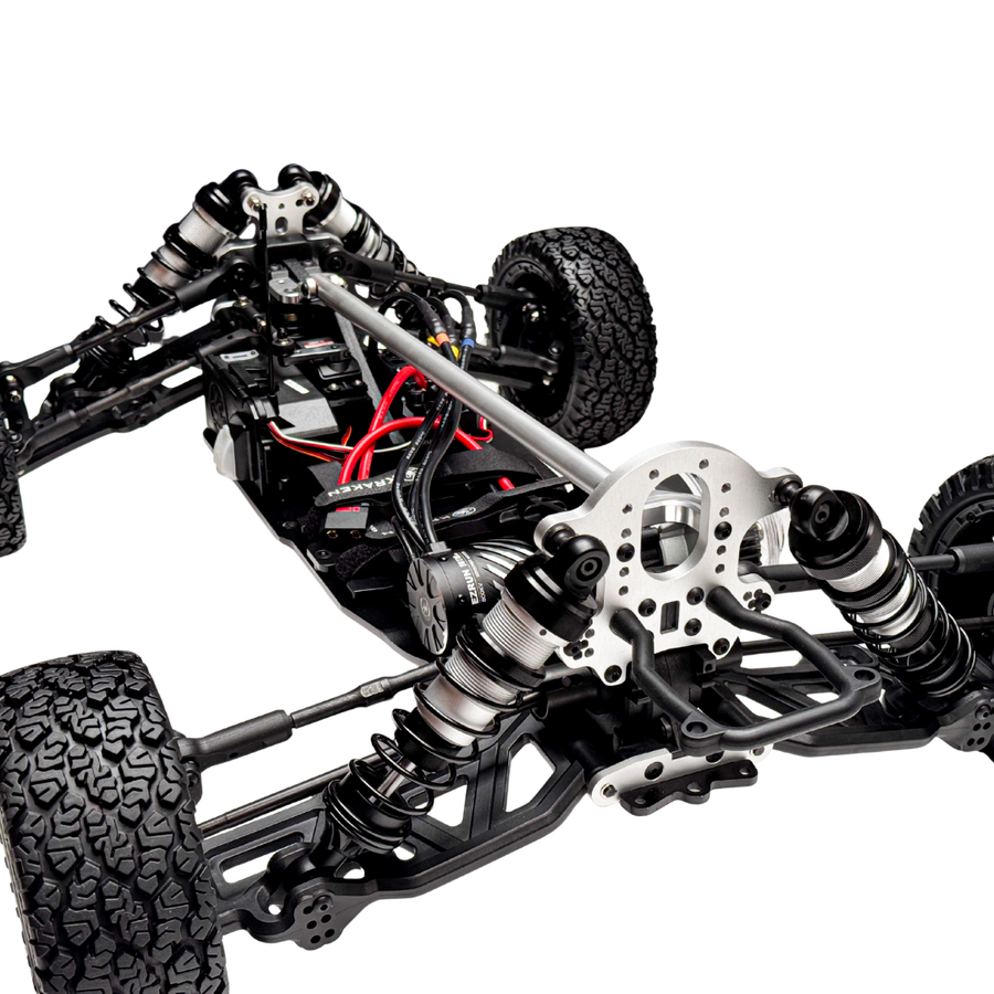 Close-up of a detailed model car chassis with suspension and wheels on a white background