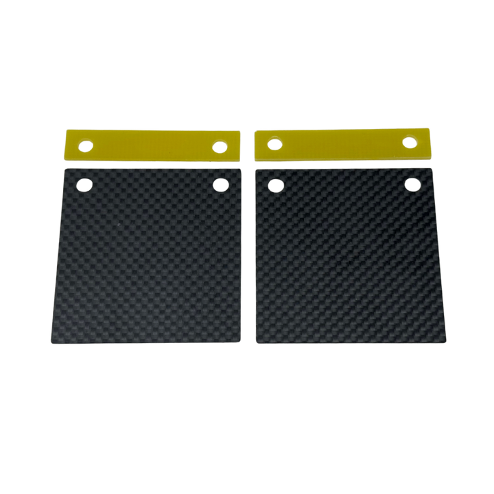 Two black carbon fiber plates with gold straps on a white background