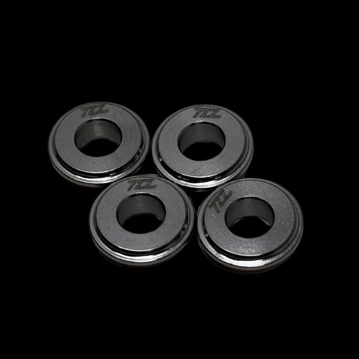 Four metallic rings with 'TZZ' branding on a black background
