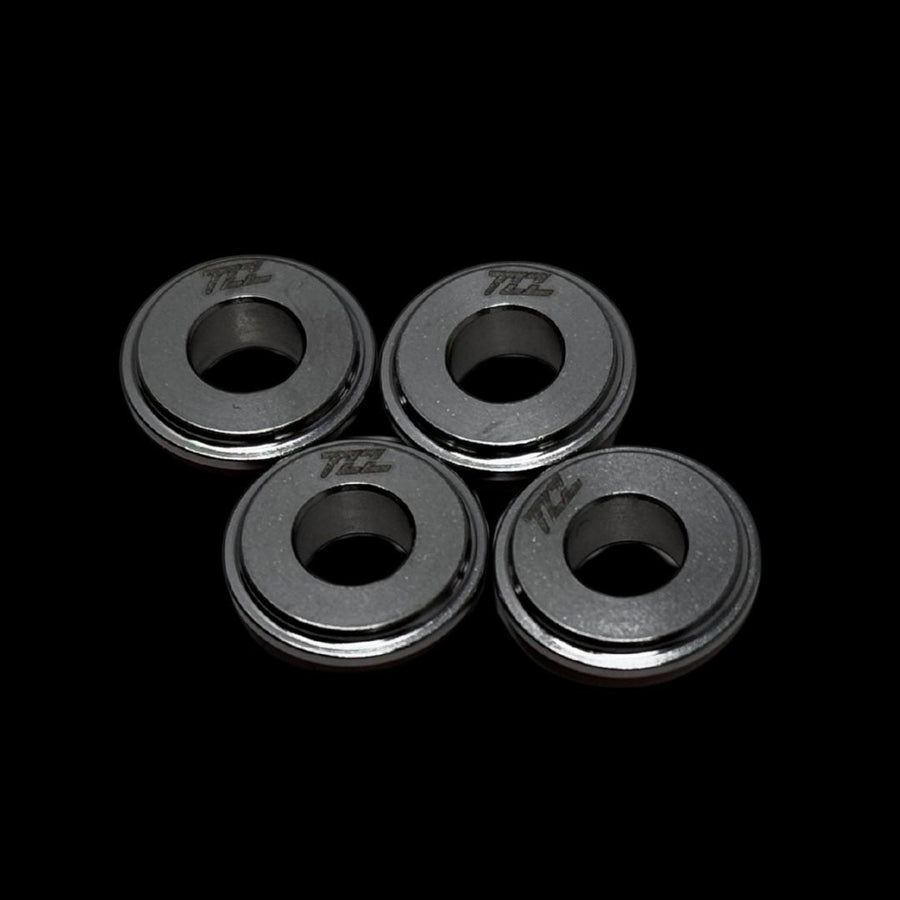 Four metallic rings with 'TZZ' branding on a black background